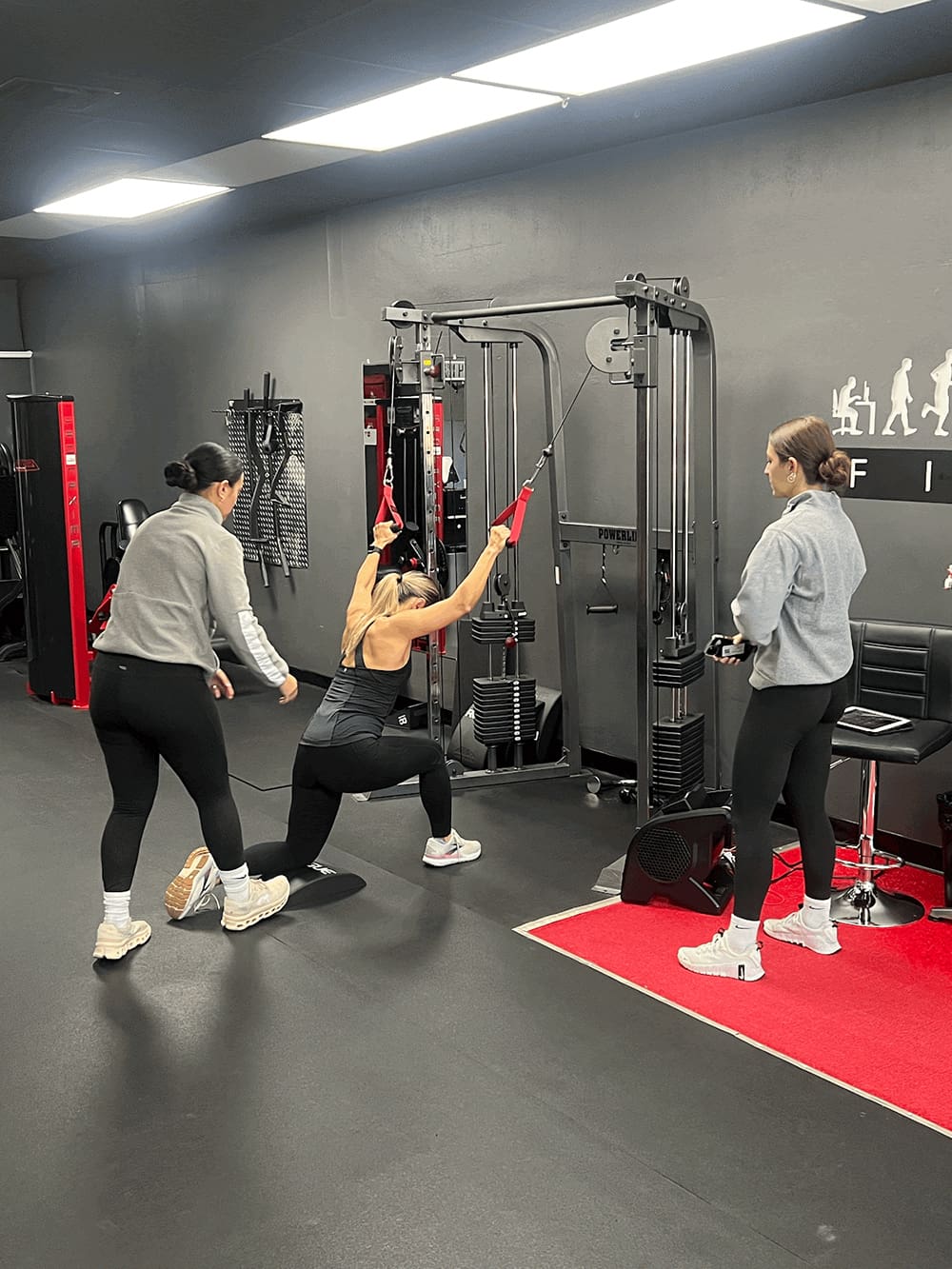 trainer - trainee from rose isle receiving form coaching on her back exercise